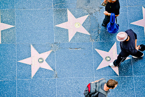 People Exploring Hollywood Walk of Fame Hollywood, USA - May 31, 2013: People Exploring Hollywood Walk of Fame, walking along famous Hollywood Boulevard, reading names of celebrities and making photos. lypsela2013 stock pictures, royalty-free photos & images