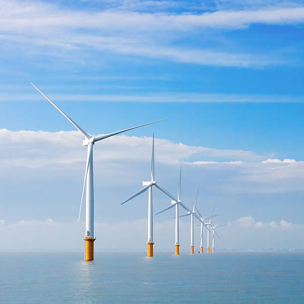 Electrical wind turbines at sea stock photo