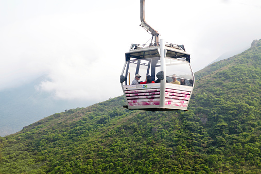 Hong Kong, China - April 16, 2011: Cable car ride to Lantau Island against hills and mountains. Lantau is the largest island in Hong Kong, located at the mouth of the Pearl River.