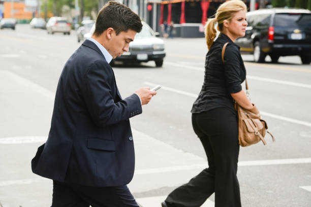 empresário usando telefone celular enquanto atravessar a rua - smart phone iphone women mobile phone - fotografias e filmes do acervo