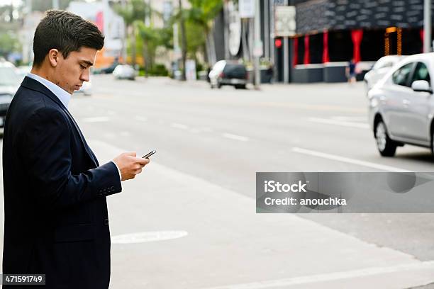 Бизнесмен С Помощью Мобильного Телефона Во Время Пересечения Улицы — стоковые фотографии и другие картинки Apple Computers