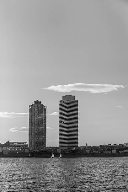 Barcelona - boats passing by Barceloneta coast line skyscrapers stock photo