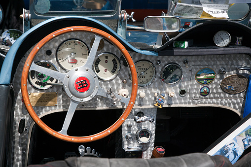 Niederkassel, Germany - June 16, 2013: Dashboard of a vintage Bugatti replica with wooden steering wheel.