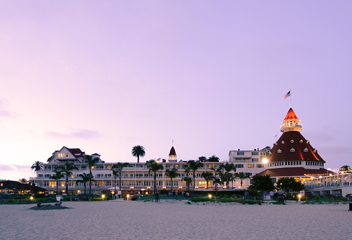 Coronado, United States - May 26, 2013: People meander about the beach as well as the Hotel Del Coronado during the nighttime. The hotel, which originally opened in 1888, was the largest resort hotel in the world at the time and currently has 680 rooms. 