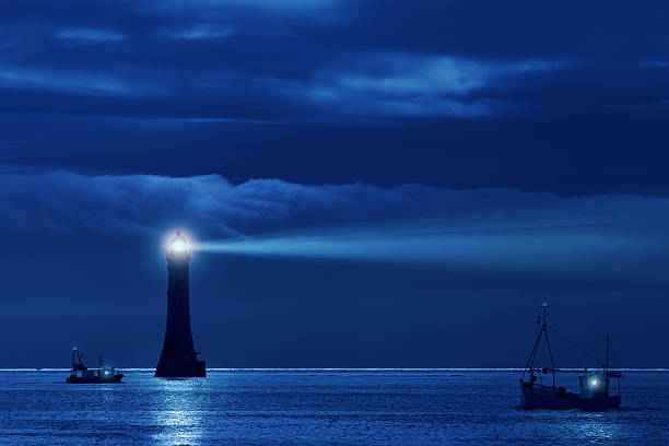 faro y los buques en la noche - beacon fotografías e imágenes de stock