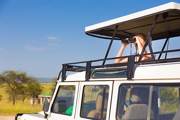 istock Woman on safari looking through binoculars. 471592990
