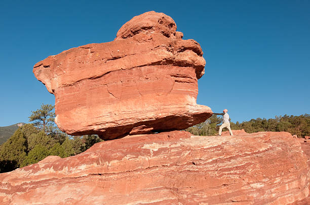 The early morning light illuminating the famous Balanced Rock located in Colorado’s Garden of the Gods with a man in foreground.