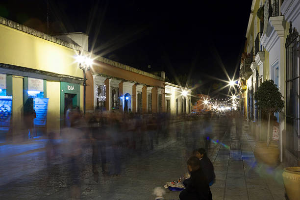 Oaxaca, Mexico - December 29, 2009: Night view of locals and tourists along the pedestrian street that goes from the Oaxaca main square or Plaza de Armas, to the Santo Domingo Church. Long exposure shoot with visible motion blur.
