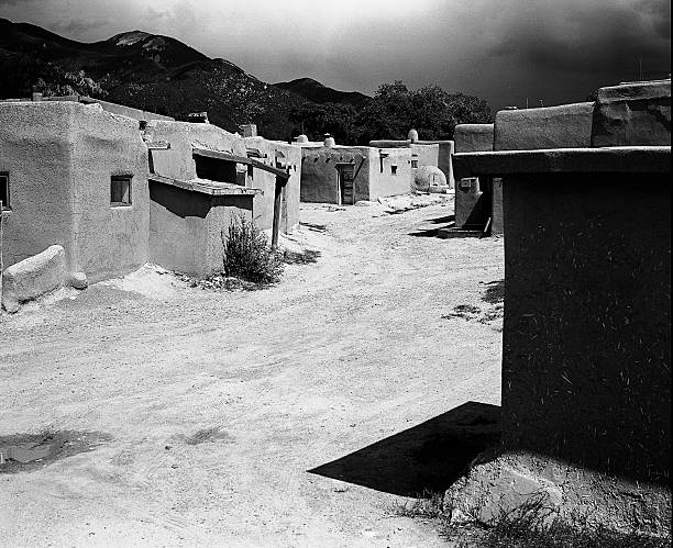 Street In The Taos Pueblo Taos, New Mexico, United States - September 7, 2011: A street in the Taos Pueblo winds through small adobe homes in Taos, New Mexico on September 7, 2011. adobe oven stock pictures, royalty-free photos & images