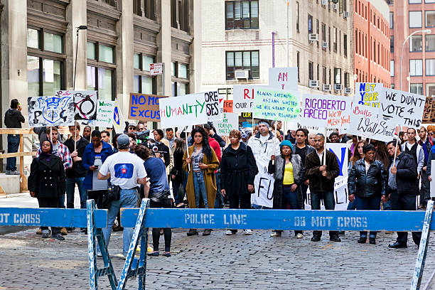 New York City, USA - June 22, 2013: People demonstrating for human rights for a film recording at Greene Street and Waverly Place in New York. They are standing behind the defined area of the police. 