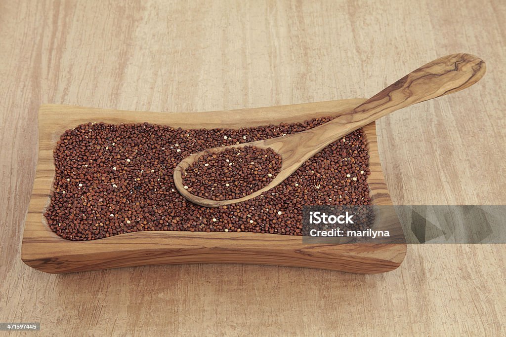 Organic Quinoa Quinoa organic grain in an olive wood bowl with spoon over papyrus background. Antioxidant Stock Photo