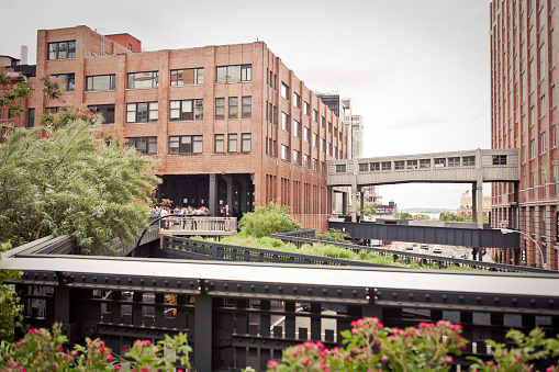 New York City, USA - June 8, 2013: A segment of High Line Park next to Chelsea market and people walking around.