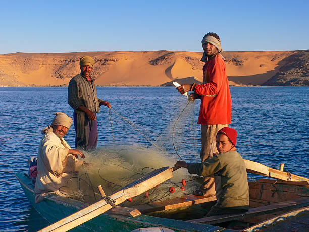 Nubian fisher on lake Nasser Lake Nasser, Egypt - December 11, 2013: Nubian fishermen with her small fisherboat on lake Nasser, catching nile perch an Tilapia.  blue nile stock pictures, royalty-free photos & images