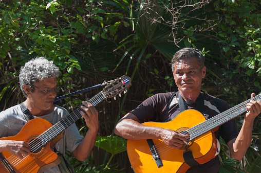 havana, Сuba - June 11, 2013: two cuban men playing a guitar in downtown havana on a sunny morning