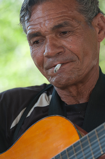 havana, Сuba - June 11, 2013: cuban man smoking a sigarte and playing the guitar