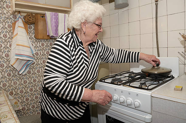 Mulher idosa prepara Comida - fotografia de stock