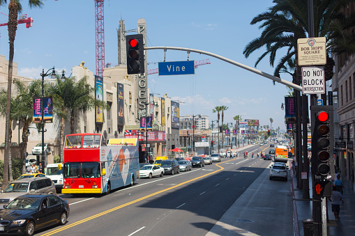 Los Angeles, California, USA - May 11, 2013: Traffic including a tourist bus banks back from traffic lights at the corner of Hollywood Boulevard and Vine Street, also known as Bob Hope Square