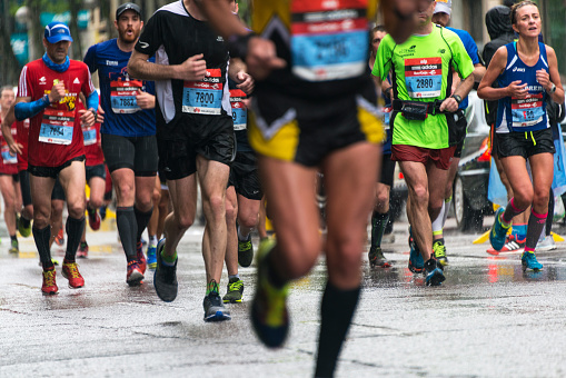 Madrid, Spain - April 26, 2015: A group of male and female athletes approach the final kilometers of the EDP Rock 'n' Roll Marathon in Madrid under heavy rain, trying to narrow the gap with the head of the race.
