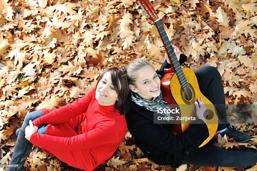 Zwei Mädchen spielt Gitarre und hat gute Zeit in der Natur - Lizenzfrei Blatt - Pflanzenbestandteile Stock-Foto