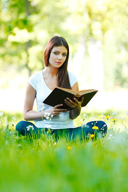 istock Woman reading book outdoors 471606847