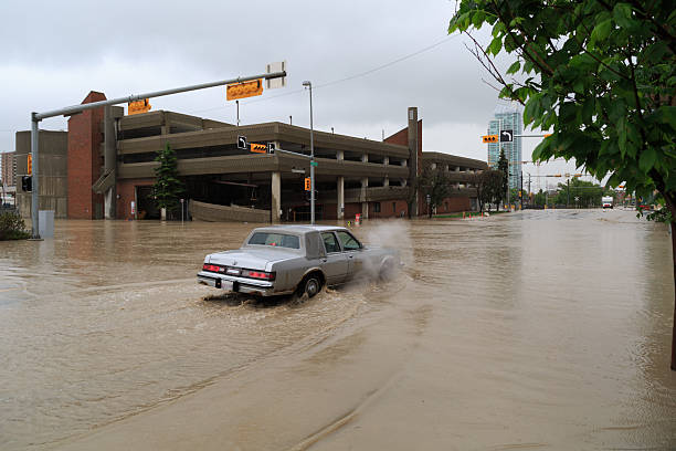 car navega una abundante 3rd street durante las inundaciones de calgary - calgary street flood alberta fotografías e imágenes de stock