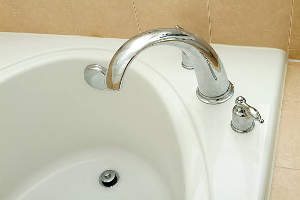 Close-up of the corner faucet of a soaking tub in a new home.