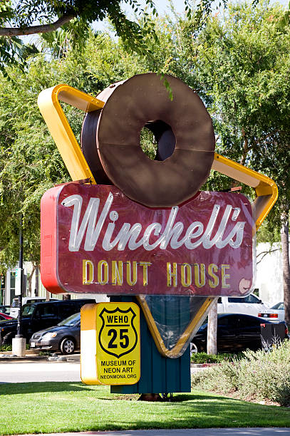 Los Angeles, California, USA - June 6, 2013: On display in Plummer Park on Santa Monica Blvd is this huge vintage Winchell's Donut House sign donated by the Route 66 Mother Road Museum to MONA, the Museum of Neon Art.