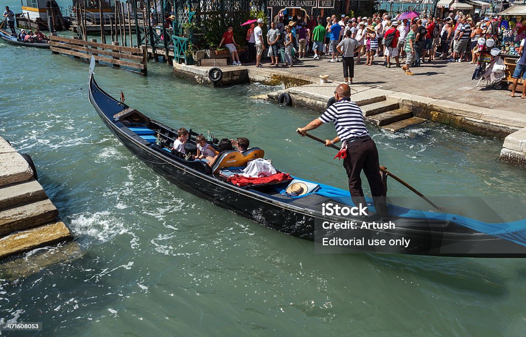Gondoliere con turisti stranieri crociera in un piccolo canale di Venezia - Foto stock royalty-free di Adulto
