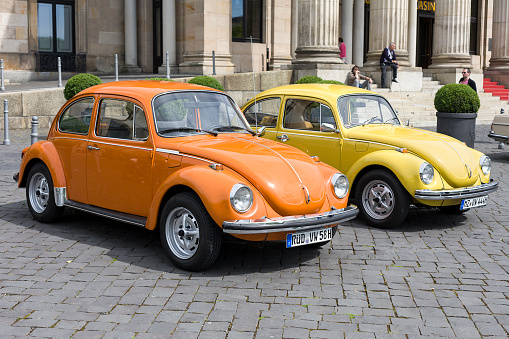 Wiesbaden, Germany - June 2, 2013: Two german vintage Volkswagen Kaefer (Beetle) at a Classic Car Convention in the city center of Wiesbaden. In the background some visitors and passersby