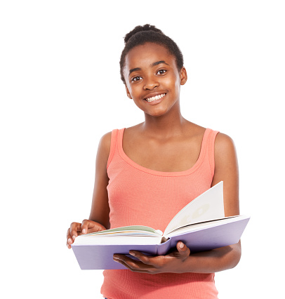 Studio portrait of a young african american girl reading a book isolated on white