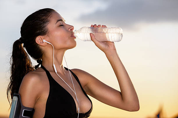 istock Young sporty woman drinking water 471609944