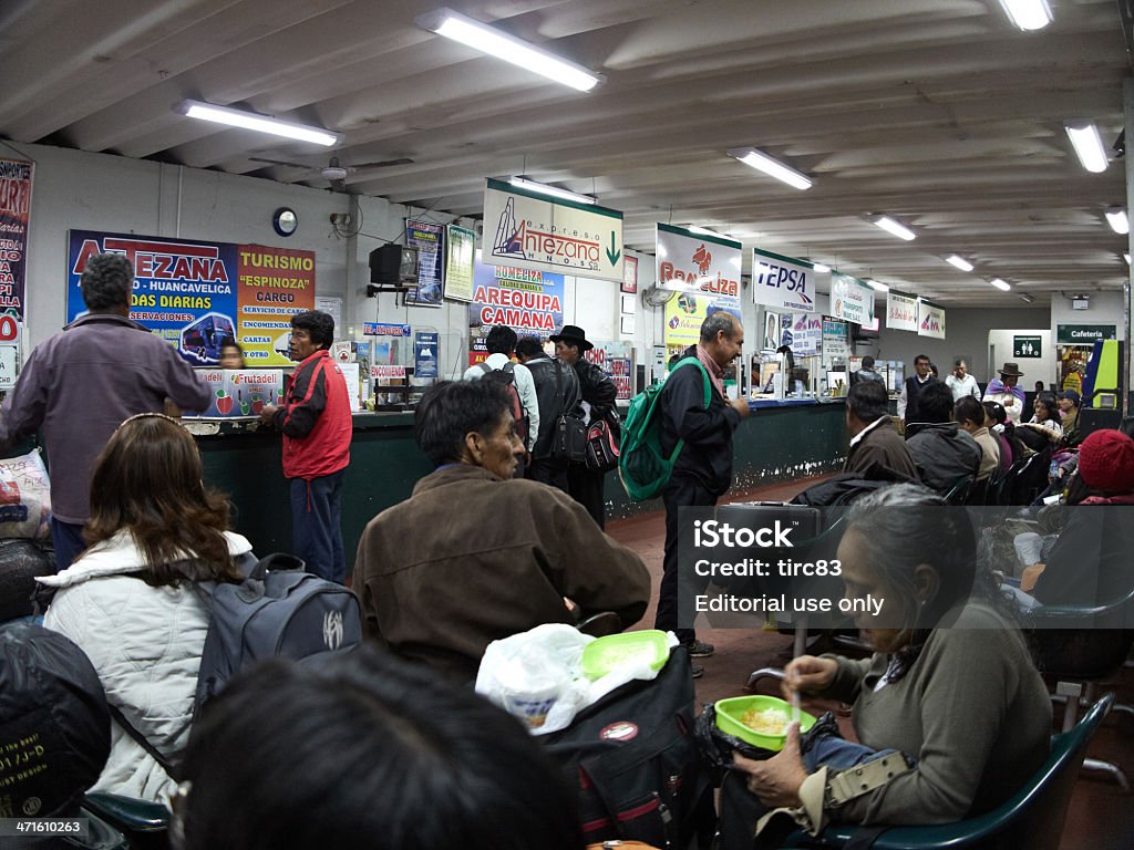 Ica bus station waiting room interior at night Ica, Peru - May 24, 2013: Ica bus station waiting room interior at night. Passengers are sitting waiting and people are working at the counters of the many bus companies Adult Stock Photo