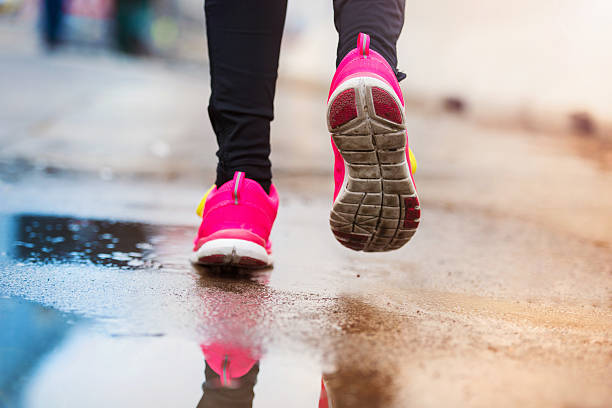 istock Young woman running in rainy weather 471610318