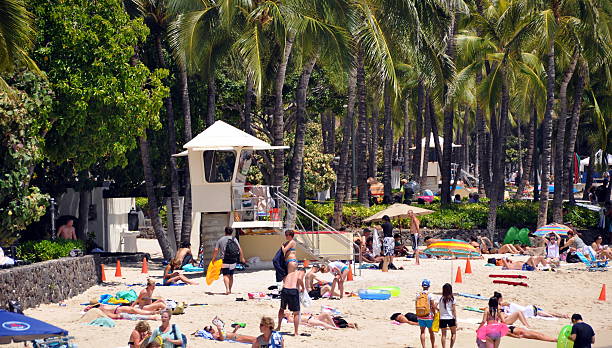 Honolulu, USA - June 25, 2013: People sunbathing on Waikiki Beach on a beautiful sunny day on Hawaii islands.