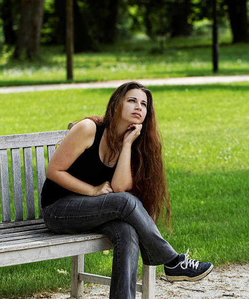 istock pretty young girl on a bench 471611677