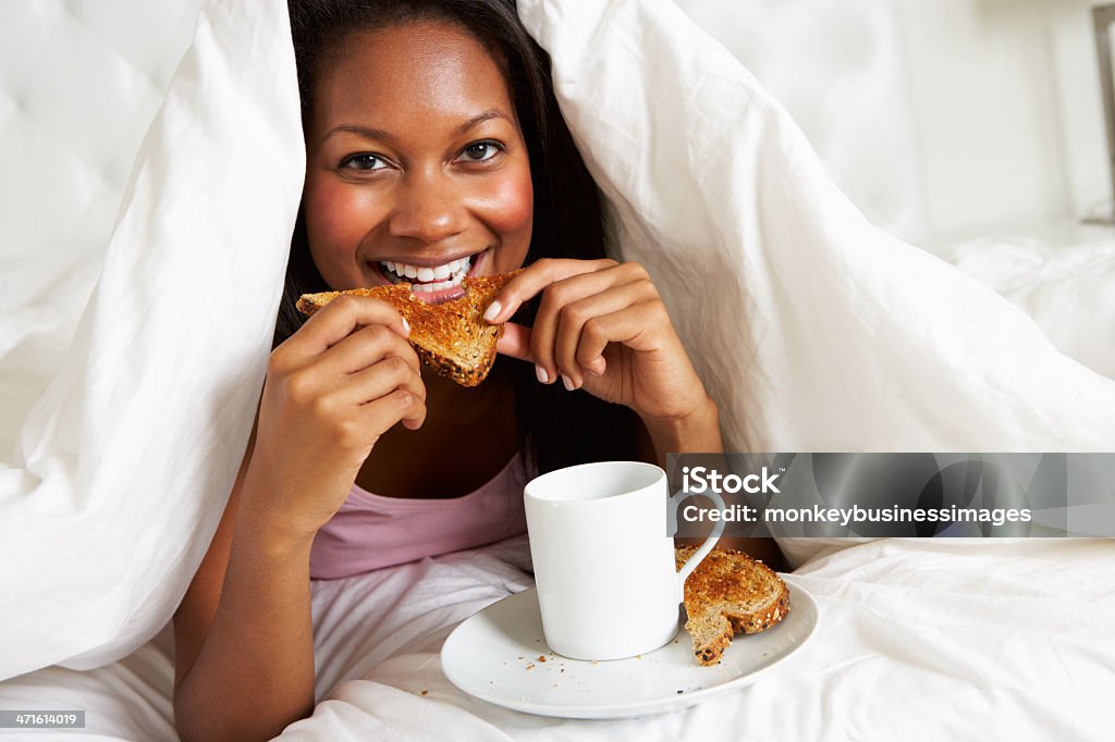 女性のベッドでの朝食をお楽しみいただけます。 - トーストのロイヤリティフリーストックフォト