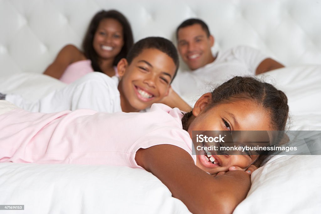 Familia relajarse juntos en la cama - Foto de stock de Afrodescendiente libre de derechos