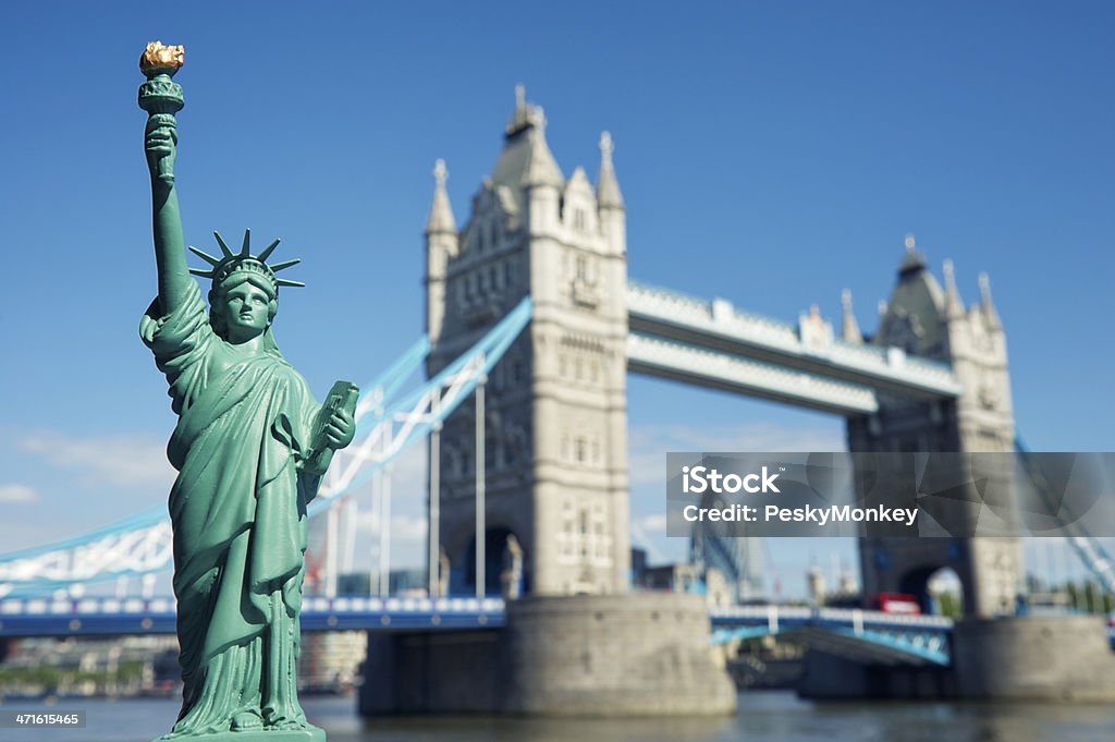 Statue of Liberty Souvenir Stands at Tower Bridge London Statue of Liberty replica souvenir stands in front of actual view of Tower Bridge, the landmark in London England Bright Stock Photo