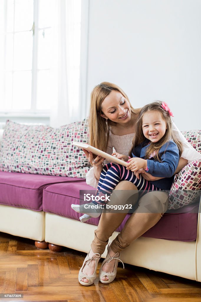 Madre e figlia lettura in camera - Foto stock royalty-free di Abbigliamento casual