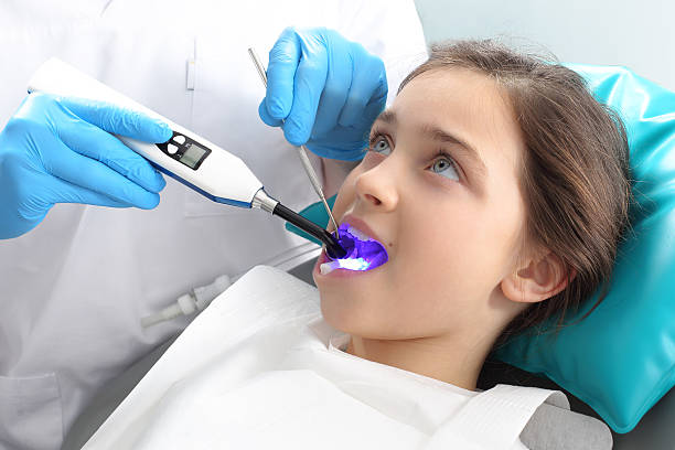 fissaggio luce-cure, il bambino nell'ufficio del dentista - dental treatment foto e immagini stock