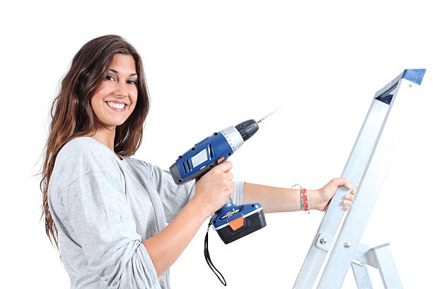 istock Beautiful woman with a drill on ladder 471618761
