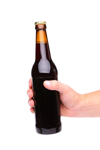 istock hand holding up a brown beer bottle 471619203
