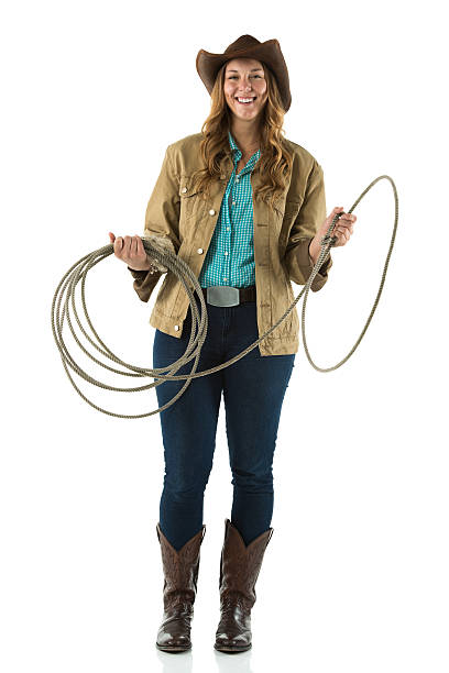 istock Cowgirl standing with a lasso and smiling 471620875