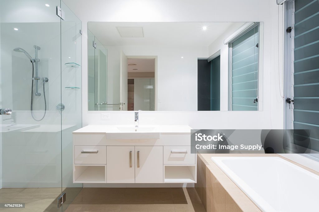 Modern bathroom view of mirror above sink and next to shower White clean modern minimal bathroom 2015 Stock Photo