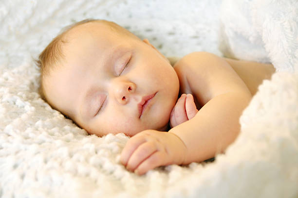 istock Sleeping Newborn Baby Girl in WHite Blankets 471621422