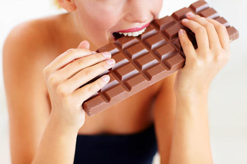 Cropped view of a young woman biting into a big slab of chocolatehttp://195.154.178.81/DATA/i_collage/pi/shoots/781564.jpg