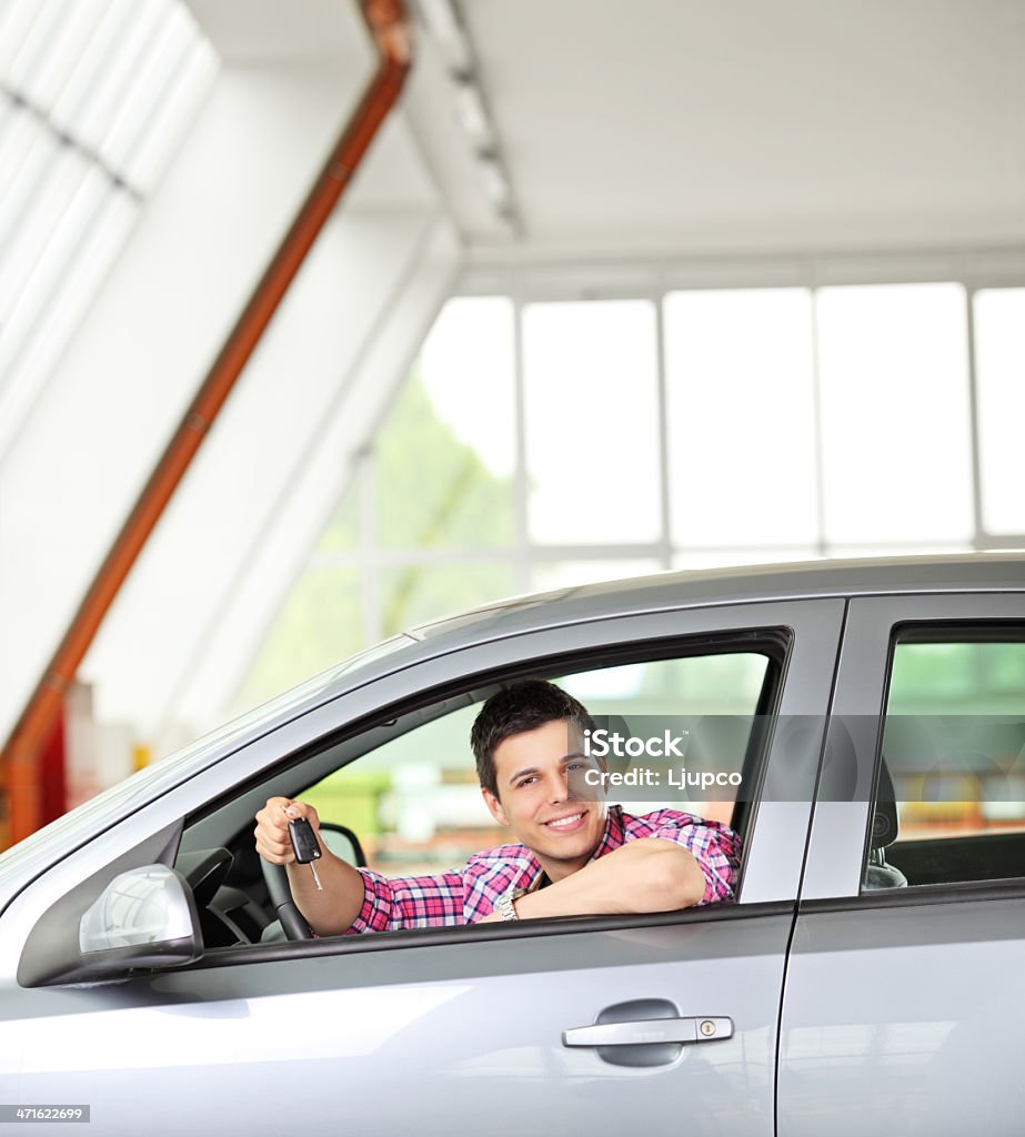 Glücklicher Mann sitzt in seinem Auto und hält einen Schlüssel - Lizenzfrei Aufregung Stock-Foto