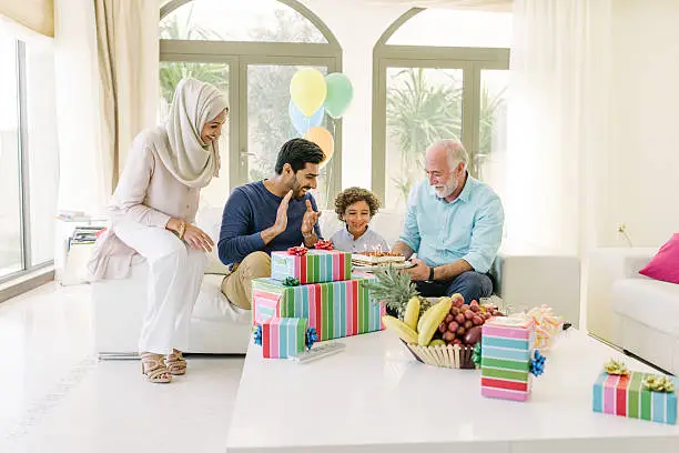 Photo of Three Genration Arabic family celebrating a childs birthday