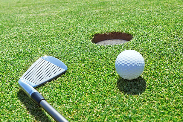 istock Golf stick and ball on the grass near hole. 471628287