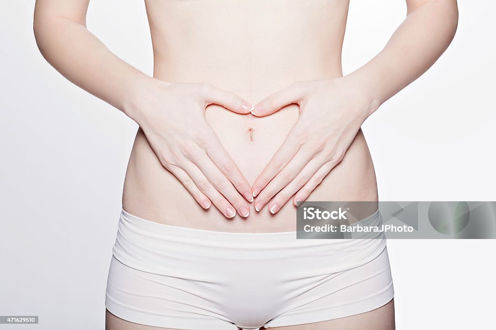 Healthy body Woman shapes a heart with her fingers. Abdomen Stock Photo